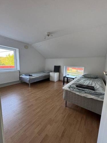 a large room with two beds and a wooden floor at Workers Stay - Worker Accommodation Torslanda - Volvo - Sweden in Gothenburg