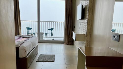 a bedroom with a bed and a balcony with a table at Clouds end Resorts Munnar in Jāmb