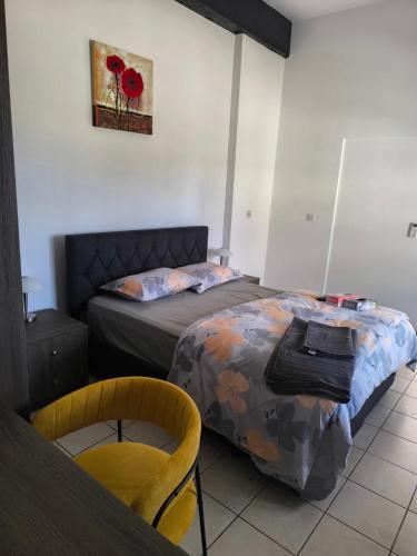 a bedroom with two beds and a table and a chair at Drouseia Karithea House in Drousha