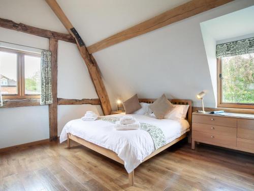 a bedroom with a bed and a dresser and two windows at 3 Bed in Worcester oc-41983 in Broadwas