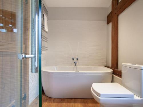 a bathroom with a white tub and a toilet at 3 Bed in Worcester oc-41983 in Broadwas