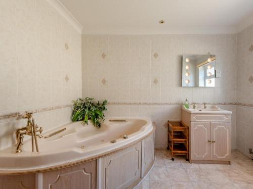 a bathroom with a large tub and a sink at 6 Bed in Tenby oc-fb220 in Tenby