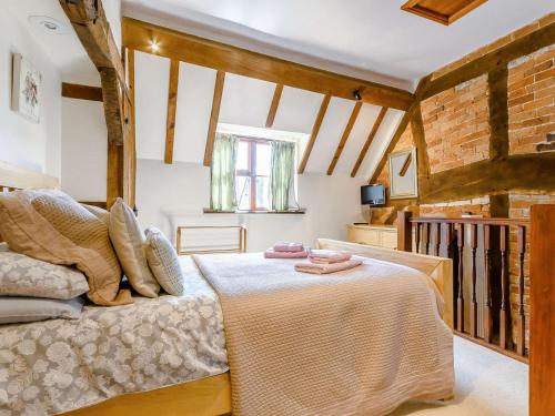 a bedroom with a bed and a brick wall at 2 Bed in Evesham oc-89476 in Bretforton