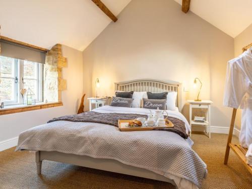 a bedroom with a bed with a tray of food on it at 1 Bed in Moreton -in- Marsh oc-53420 in Blockley