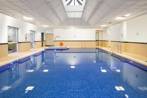a large swimming pool with blue tiles on the floor at Crowne Plaza Glasgow by IHG in Glasgow