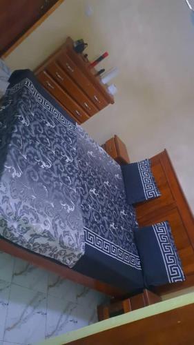 a bed with a blue and white bedspread on it at Secka Apartment in Sukuta