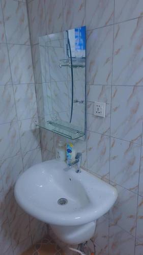 a bathroom with a white sink and a mirror at Secka Apartment in Sukuta