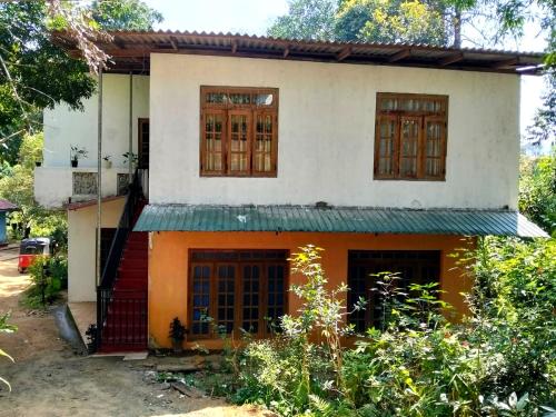 a small house with orange doors and windows at Ramanayaka Serenity Villa in Bandarawela