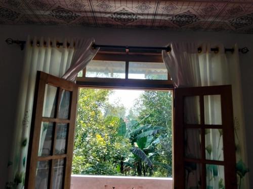 an open window with a view of a tree at Ramanayaka Serenity Villa in Bandarawela