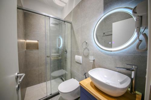 a bathroom with a shower and a sink and a mirror at Denis Studios Durres in Durrës