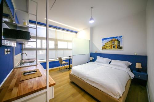 a bedroom with a bed and a desk and a sink at Denis Studios Durres in Durrës