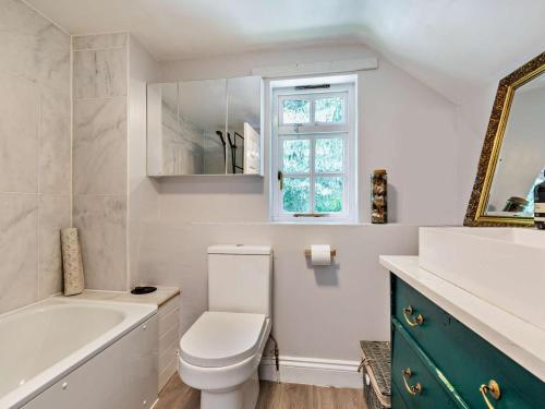a bathroom with a toilet and a tub and a window at 3 Bed in Buckingham oc-94701 in Finmere