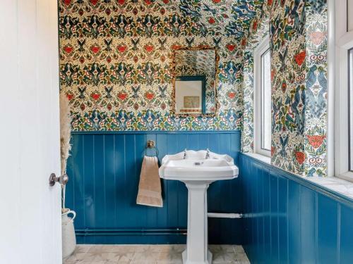 a blue bathroom with a sink and a mirror at 3 Bed in Malvern oc-90775 in Mathon
