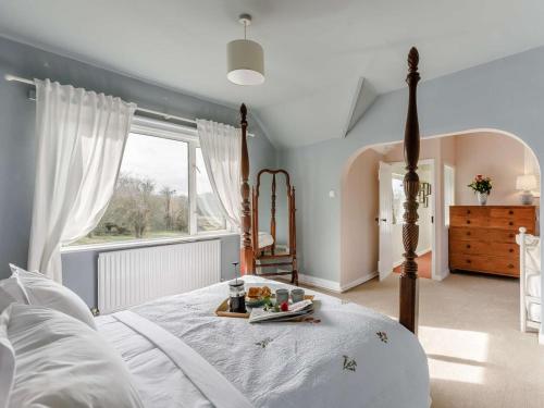a bedroom with a bed with a tray of fruit on it at 3 Bed in Malvern oc-90775 in Mathon