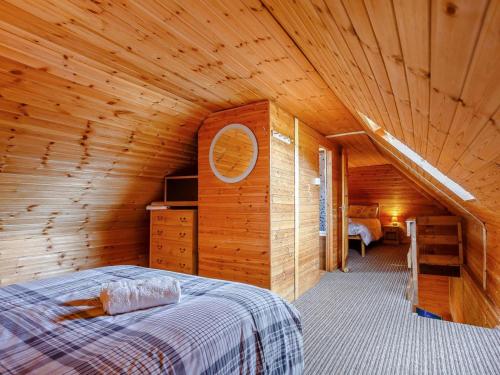 a bedroom with a bed in a wooden cabin at 1 Bed in Gairloch oc-ca044 in Gairloch