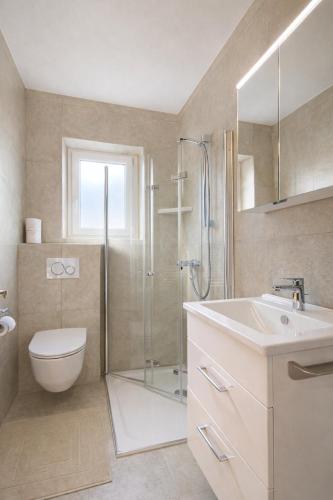 a bathroom with a shower and a toilet and a sink at Seehaus Gori in Maria Wörth