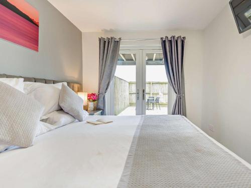 a bedroom with a large white bed and sliding glass doors at 2 Bed in Castle Douglas oc-59638 in Castle Douglas