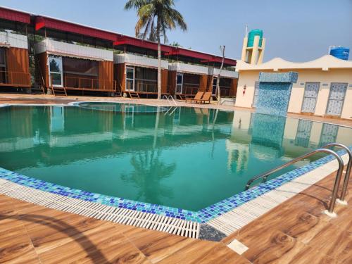 a swimming pool in front of a building at Sheoak Retreat Tajpur in Tajpur