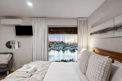 a bedroom with a bed and a view of a harbor at Swainson on Lady Gowrie in Largs