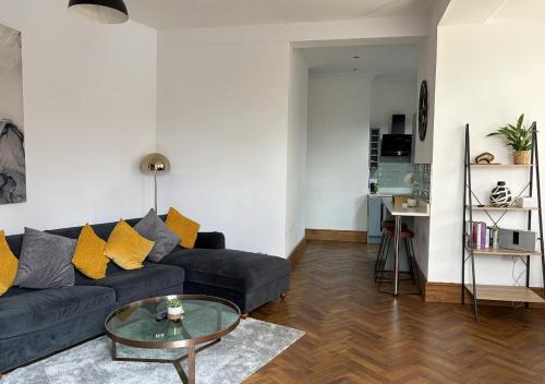 a living room with a black couch and a glass table at Stylish 1-Bedroom Apartment in Chapel Allerton with Free Parking in Moortown