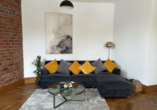 a living room with a blue couch with yellow pillows at Stylish 1-Bedroom Apartment in Chapel Allerton with Free Parking in Moortown