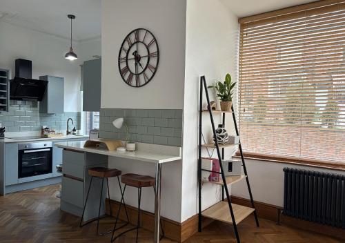 a kitchen with a counter and a clock on the wall at Stylish 1-Bedroom Apartment in Chapel Allerton with Free Parking in Moortown