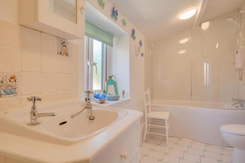 a bathroom with a sink and a tub and a toilet at 3 Bed in Brancaster oc-2153 in Brancaster