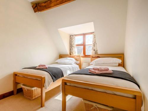 two twin beds in a room with a window at 3 Bed in Evesham oc-89477 in Bretforton