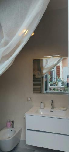 a white bathroom with a sink and a mirror at Millenovecento in Cremona