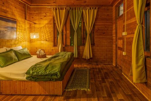 a bedroom with a bed in a wooden room at Riverside Mudhouse Duplex Cottage by Kahani in Jibhi