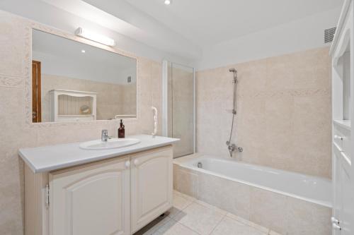a bathroom with a sink and a tub and a mirror at Villa Olivia - Golfe de Saint-Tropez in Cogolin