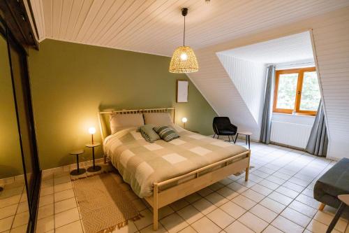 a bedroom with a bed and a chair in a room at Le Louis Vakantiehuis in Lanaken