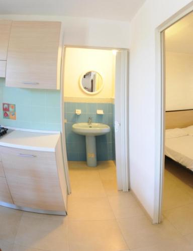a small bathroom with a sink and a bed at Villaggio Santo Stefano in Vieste