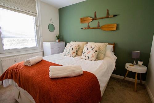 a bedroom with a bed with towels on it at Beach View - A Truly Stunning House Opposite The Sea! Sleeps 10! Families, Friends, Contractors and Pets are all Welcome! in Sandgate