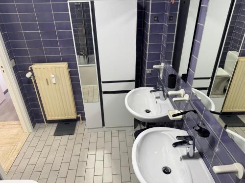 a bathroom with two sinks and two mirrors at Casa Ghentele in Blankenberge