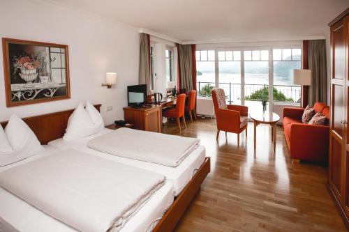 a hotel room with a bed and a living room at Seehotel Billroth in Sankt Gilgen