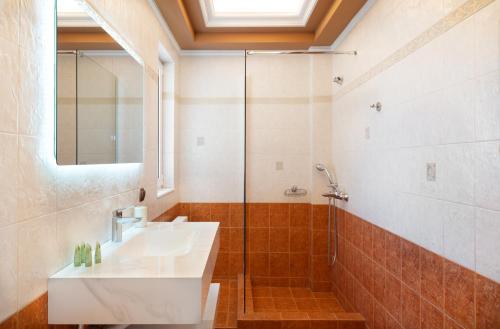 a bathroom with a sink and a shower at Phoceus Poolfront Grande Villa in Palaia Fokaia