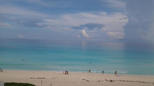 a group of people standing on a beach at Ocean View Condo in Cancún