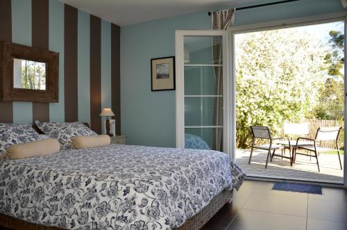 a bedroom with a bed and a sliding glass door at La Villa Belle in Belle-et-Houllefort