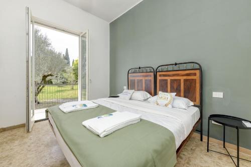 two beds in a room with a large window at MGH - Villa Sirmione in Sirmione