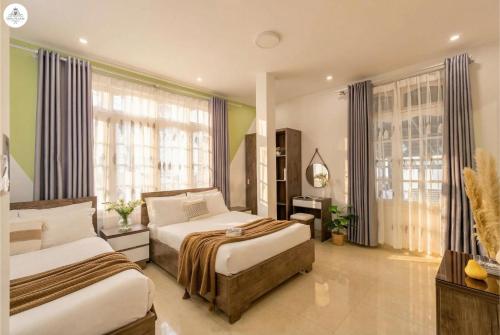 a bedroom with two beds and a large window at GreenMeadow Central Boutique in Da Lat