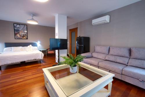a living room with a couch and a bed at Rual Suites By Cuencaloft in Cuenca