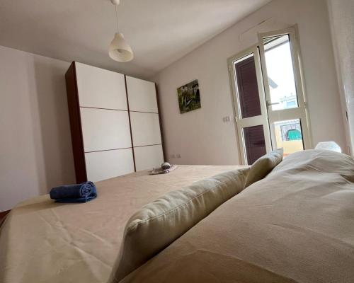 a bedroom with a large bed and a large window at Casa FLORE in Orosei