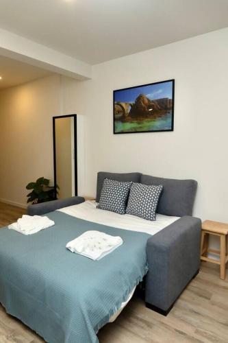 a bedroom with a large bed with a blue blanket at Cor de Mar • Pátio • 2 Quartos • Centro Histórico in Peniche