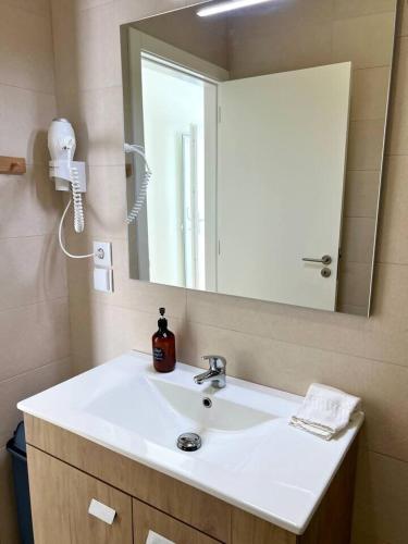 a bathroom with a sink and a mirror at Cor de Mar • Pátio • 2 Quartos • Centro Histórico in Peniche