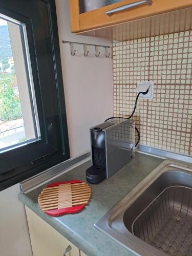 a kitchen counter with a microwave and a sink at CRYSTAL BAY in Paleo Tsifliki