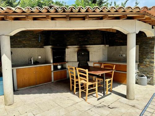an outdoor kitchen with a table and chairs under a pavilion at Studio 2 - Loc Conciergerie in Trappes