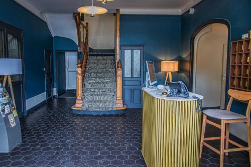 a room with a staircase and a desk with a phone at Hôtel de France - Beaune in Beaune
