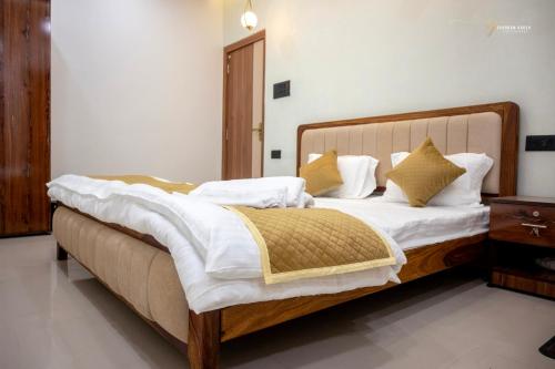 a bedroom with a bed with white sheets and yellow pillows at Skyline signature in Rānchī