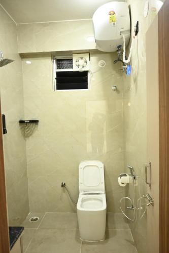 a small bathroom with a toilet and a window at Skyline signature in Rānchī